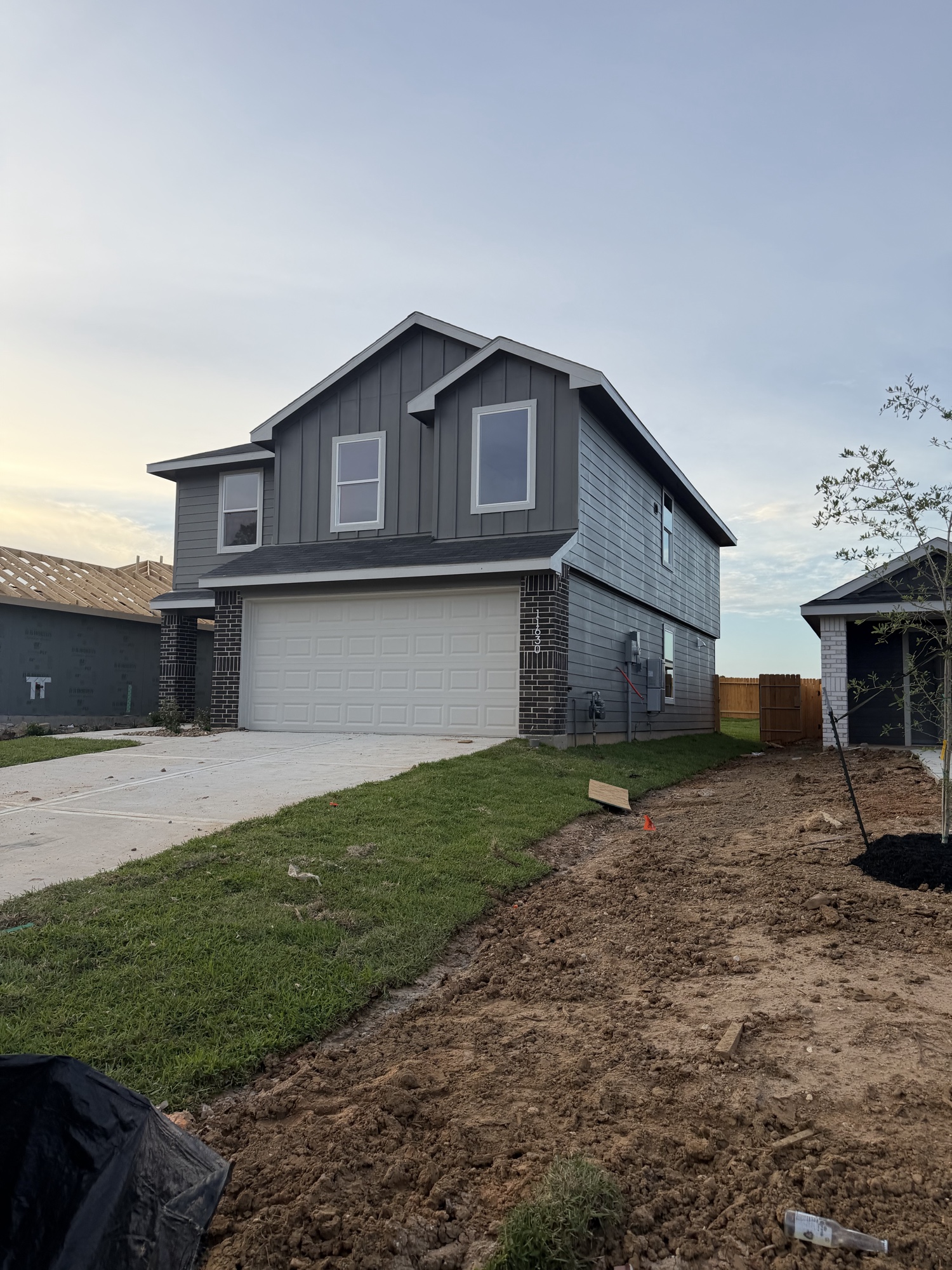 Completed two-story house exterior with board and batten siding at sunset