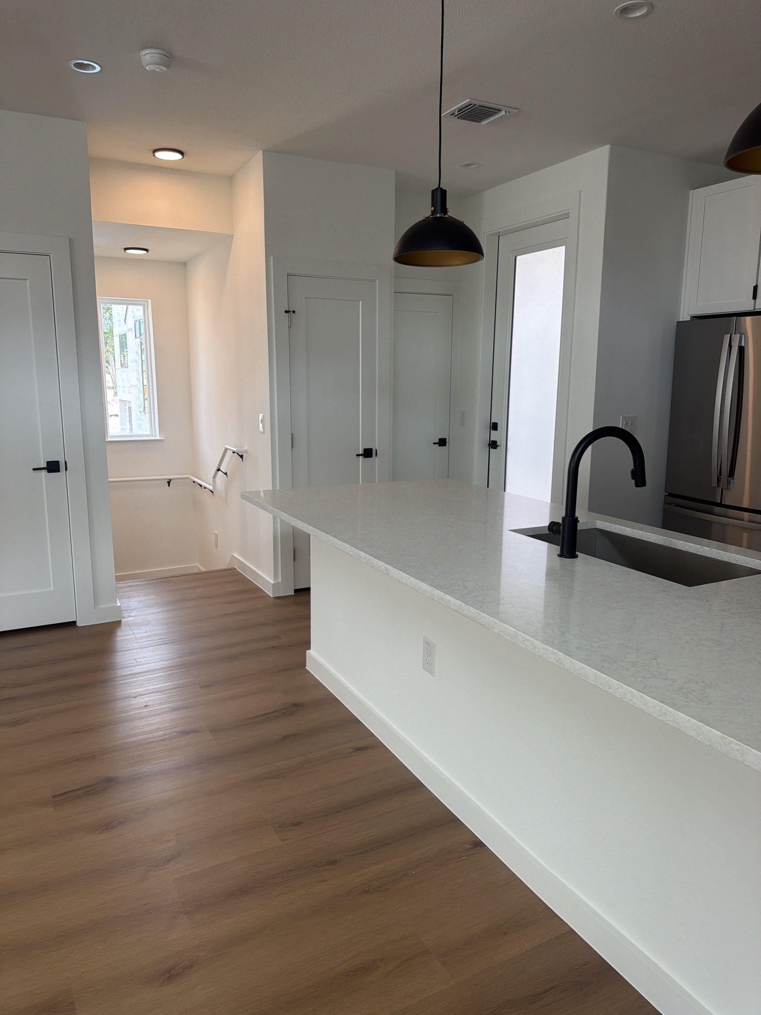 Open plan kitchen with island and staircase view