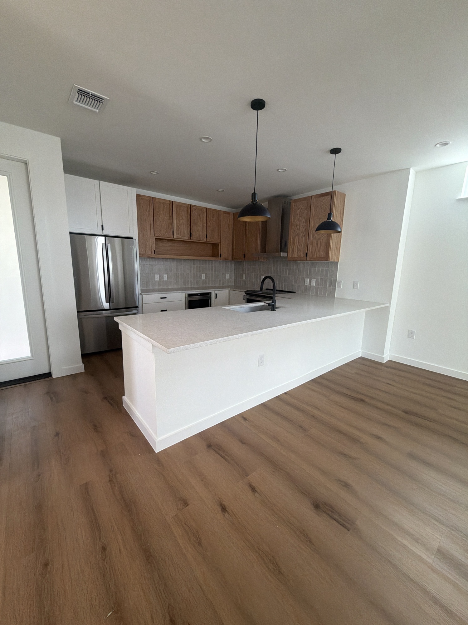 Kitchen renovation with island, wood and white cabinets, LVP flooring