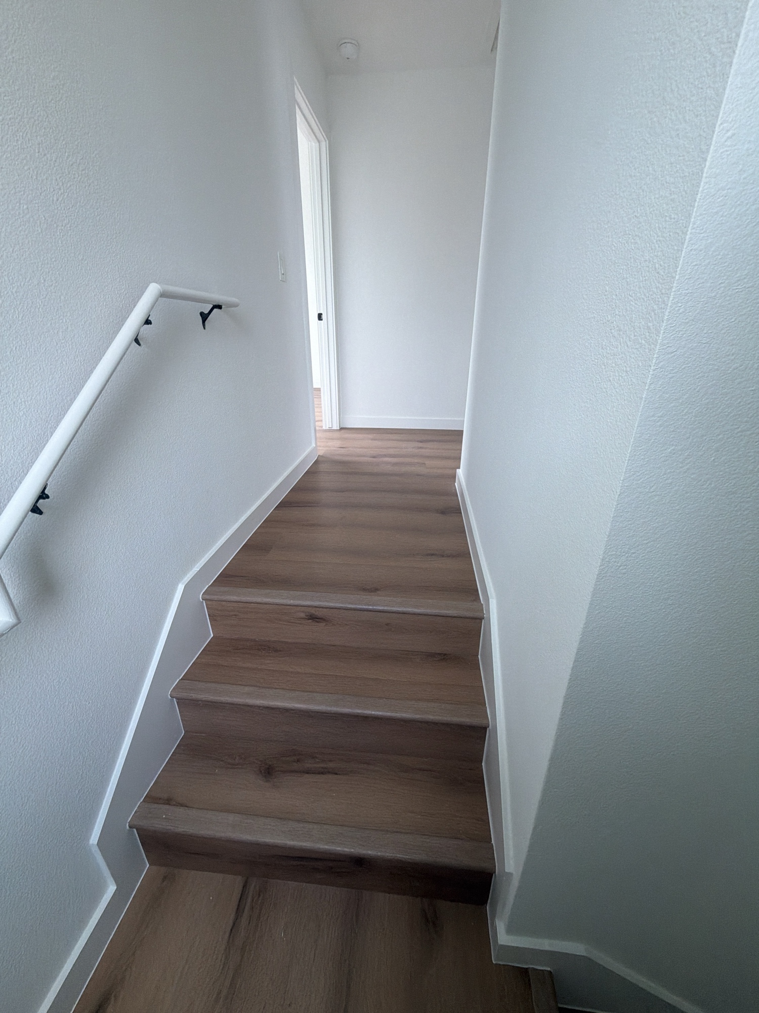 Dark wood LVP staircase looking up